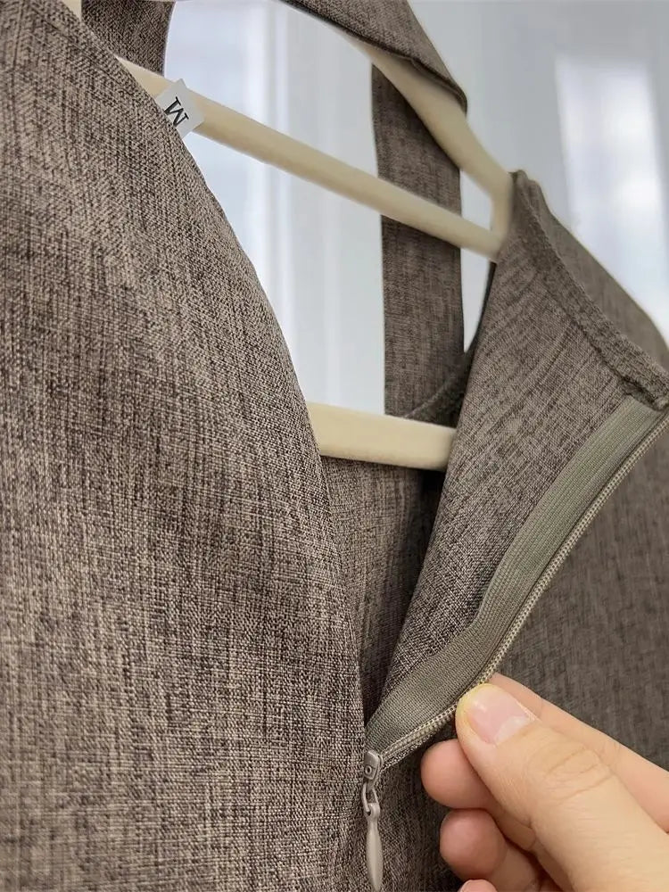 Brown textured jacket with a zipper being adjusted on a hanger against a white background
