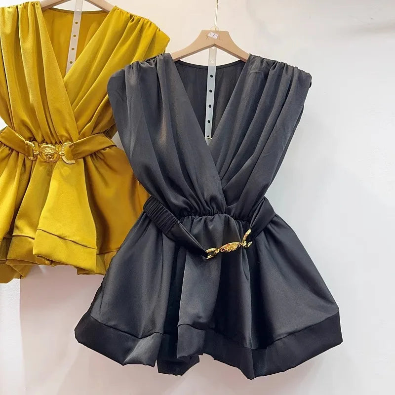 Yellow and gray rompers with gold belts on hangers against a white background