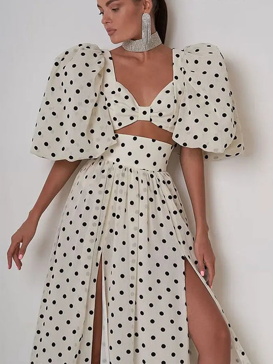 Woman wearing a polka dot dress with puff sleeves, standing against a plain background with 'Trafza' branding.