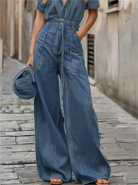 Person wearing a blue denim jumpsuit on a stone pavement.