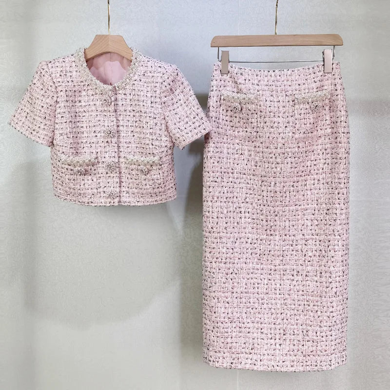 Pink textured skirt and cropped top set on hangers against a light gray background