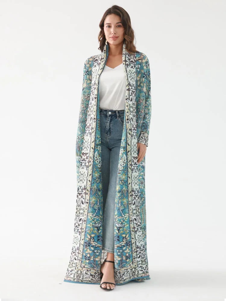 Woman wearing a long, patterned coat over a white top and jeans on a white background