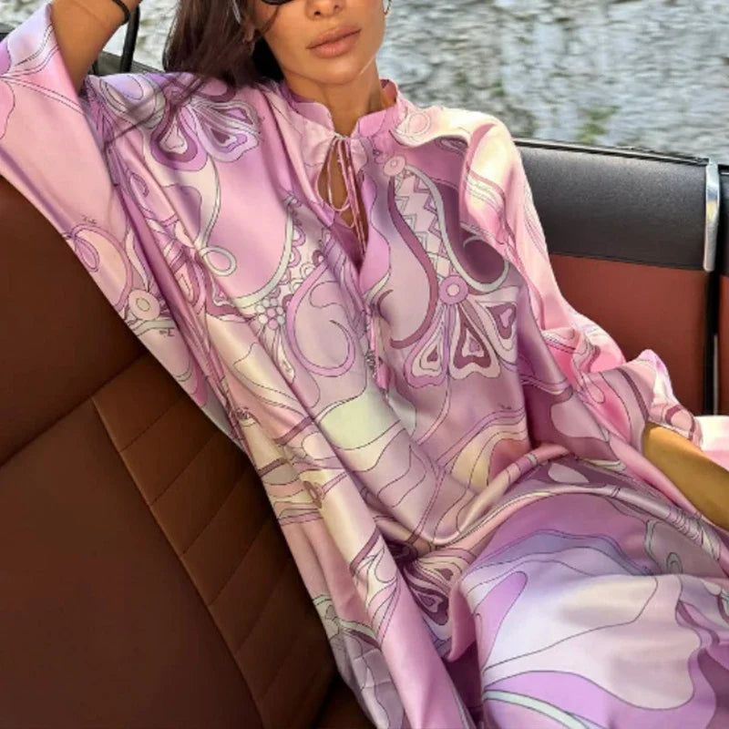 Woman sitting on a boat wearing a pink patterned dress.