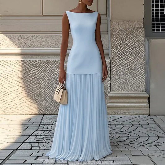 Woman wearing a light blue dress standing on a stone pavement.