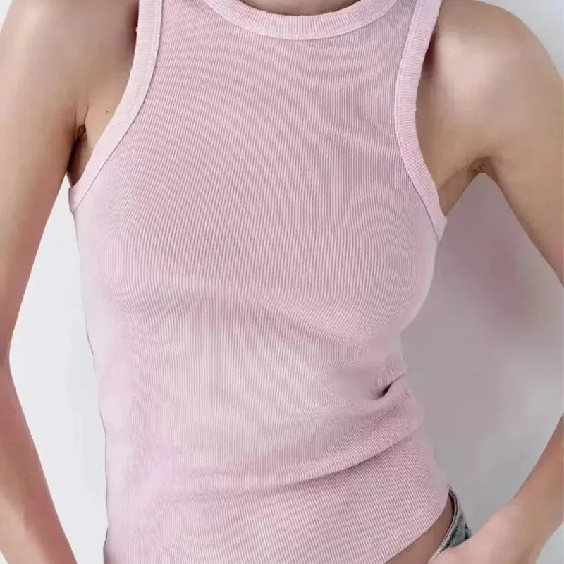 Pink ribbed tank top worn by a person on a plain background