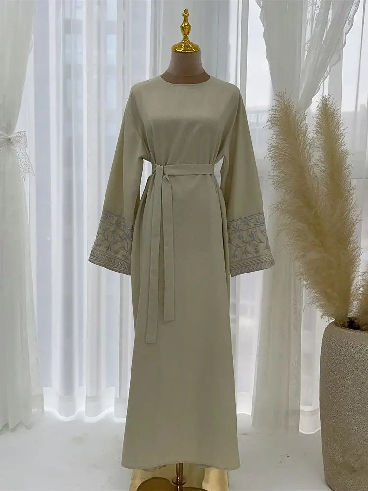 Beige dress on a mannequin with a white curtain background