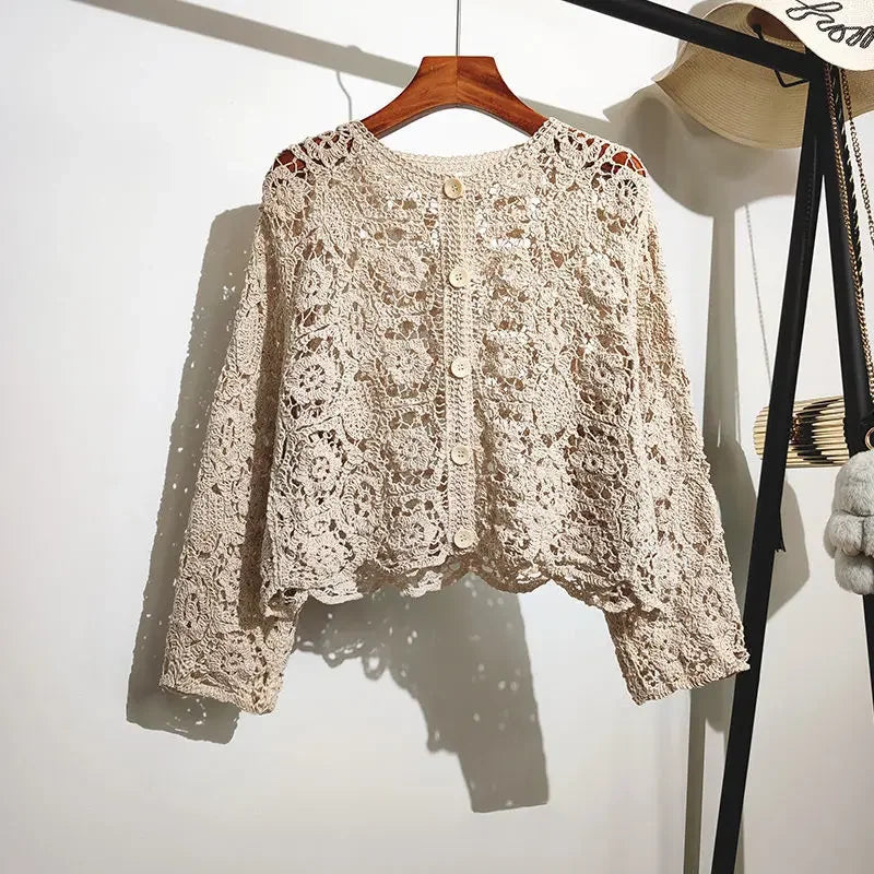 Beige lace cardigan on a wooden hanger against a white background