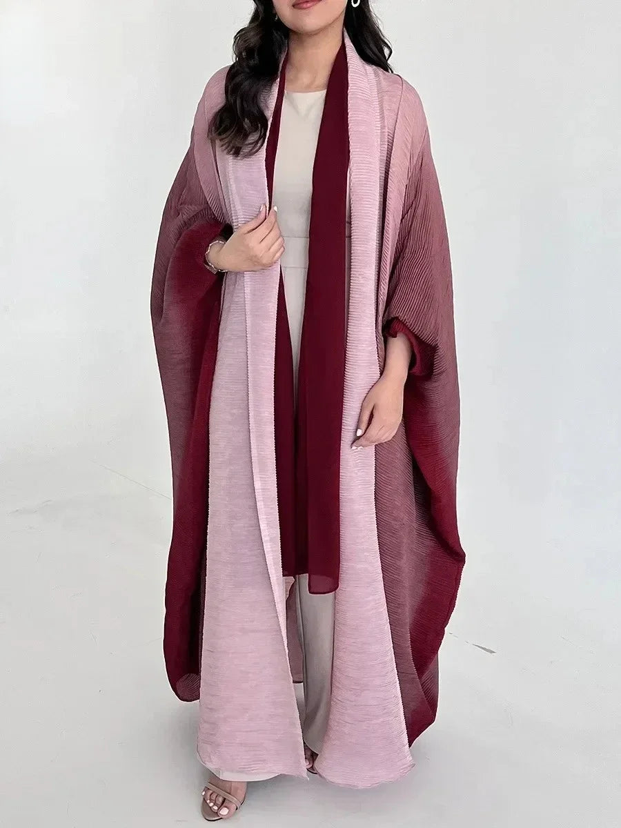 Woman wearing a long, light pink dress with a matching shawl on a white background
