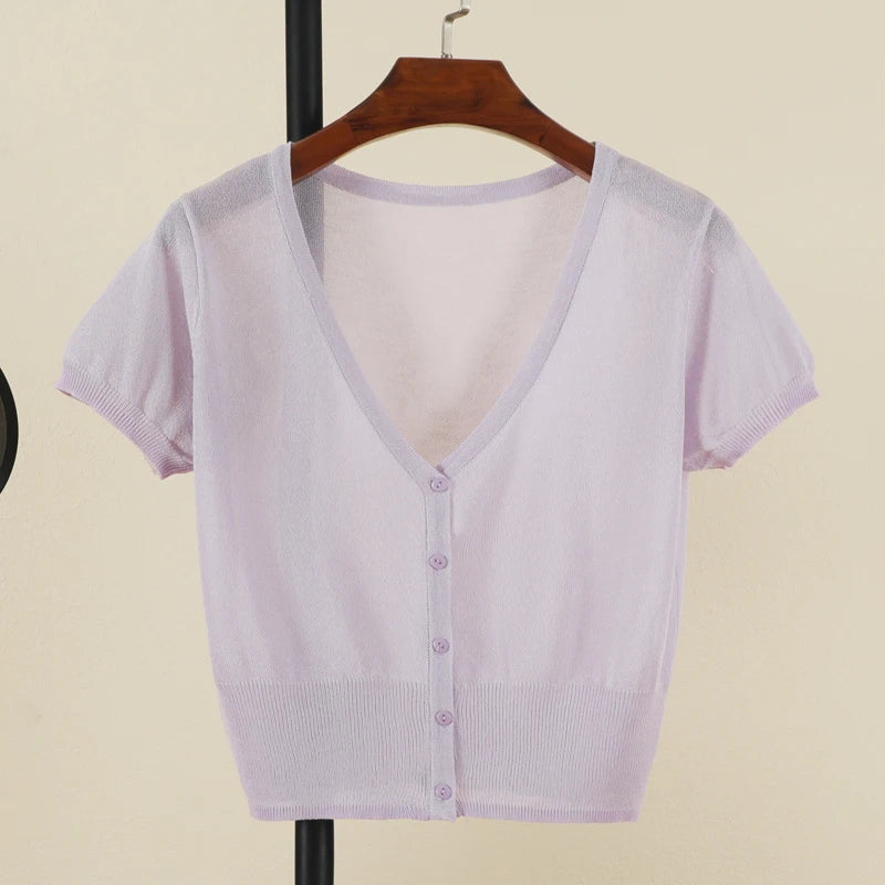 Light purple short-sleeve cardigan on a hanger against a beige background