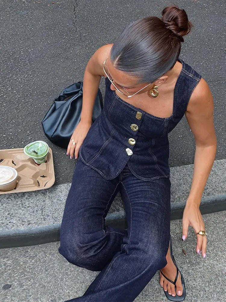 Woman in a denim outfit sitting on the ground with a tray of food.