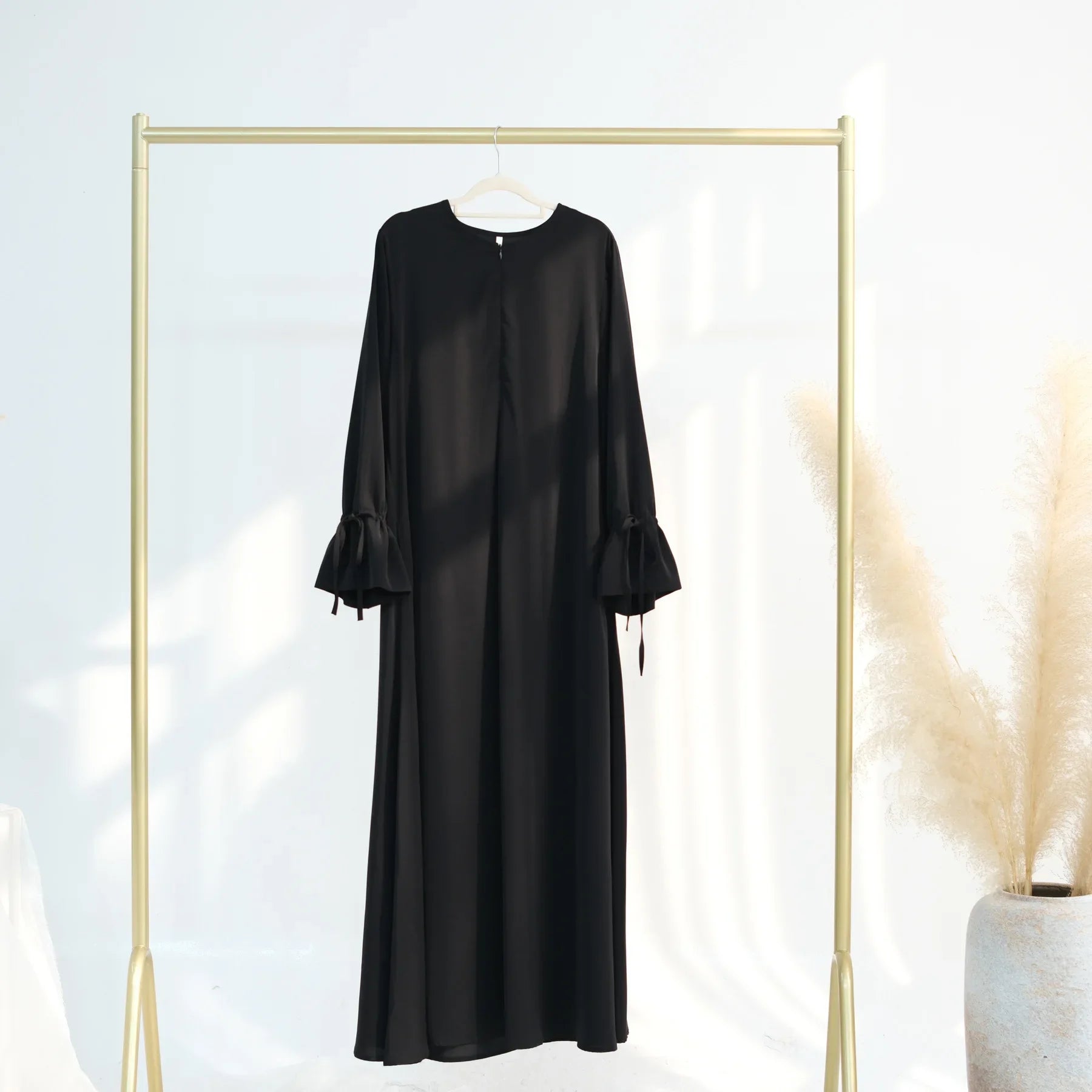 Black dress on a hanger against a white background