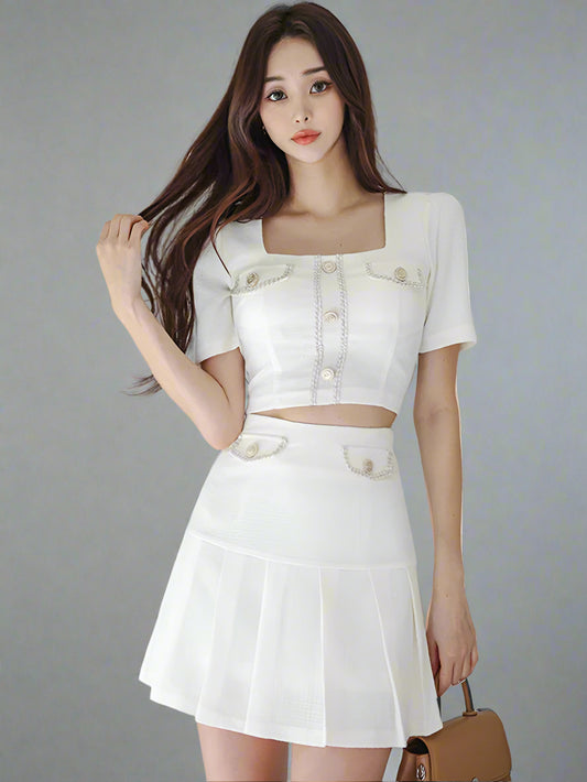Woman wearing a white outfit with a textured white wall background