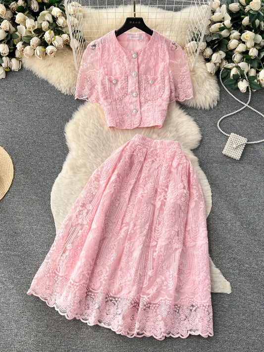 Pink lace dress set on a decorative rug with floral background