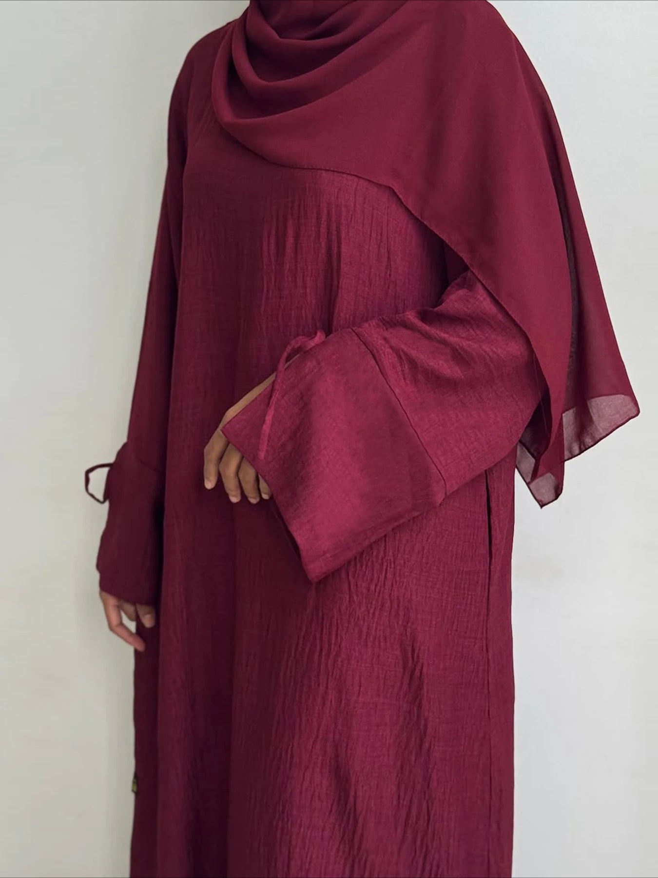 Maroon abaya with long sleeves on a white background