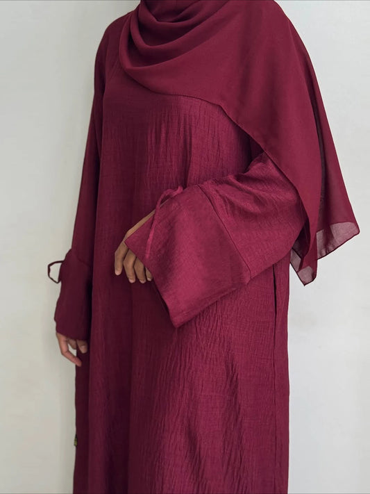 Maroon abaya with long sleeves on a white background