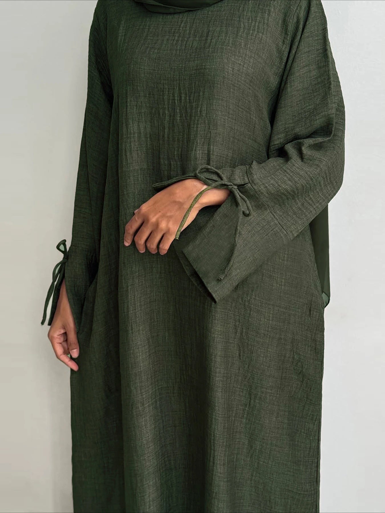 Green dress with long sleeves and a plain background