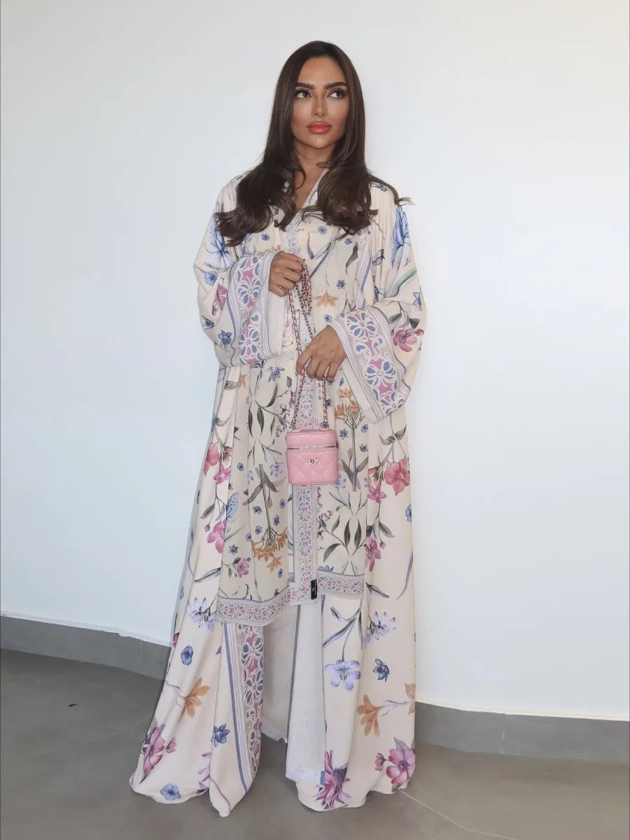 Woman wearing a floral dress holding a pink handbag against a white background