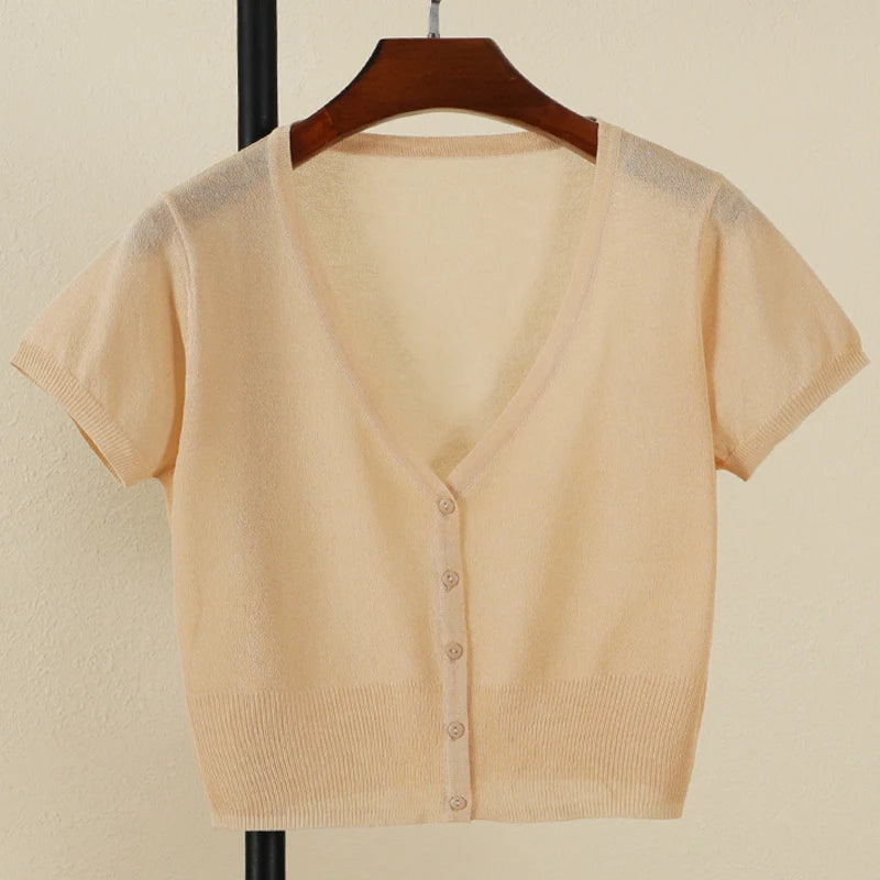 Beige short-sleeve cardigan on a hanger against a beige background