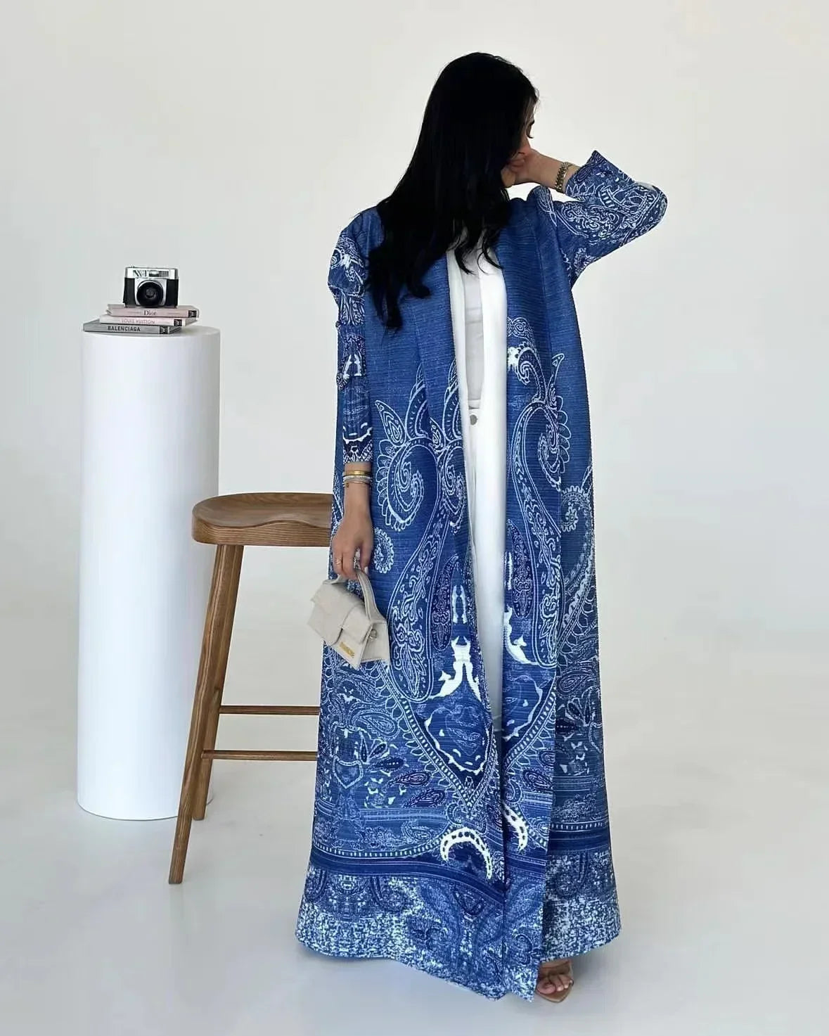 Woman wearing a blue patterned dress with a white background
