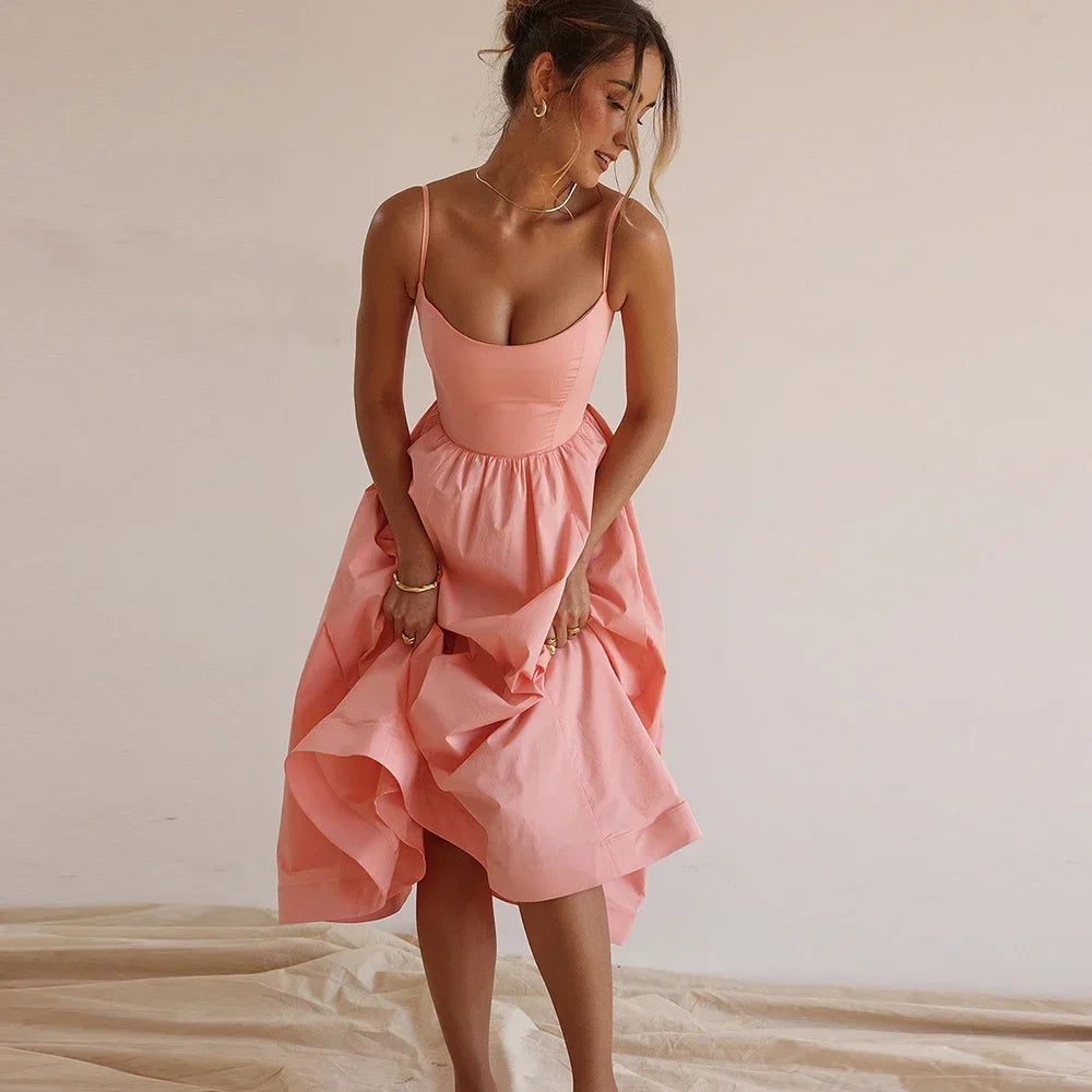 Woman wearing a pink dress against a plain background