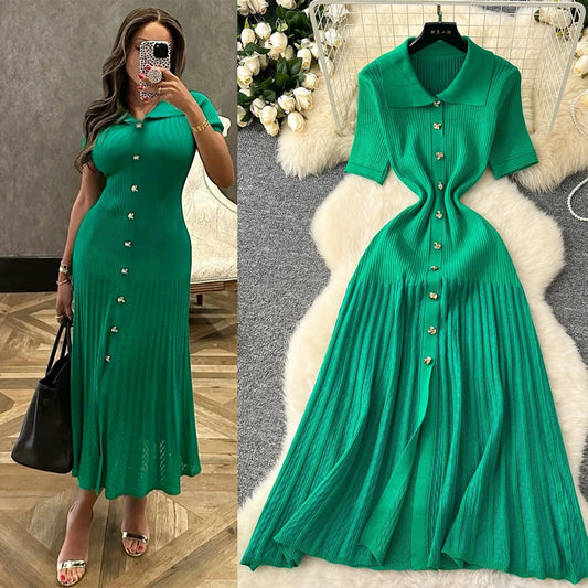 Green dress with buttons on a hanger and worn by a woman.