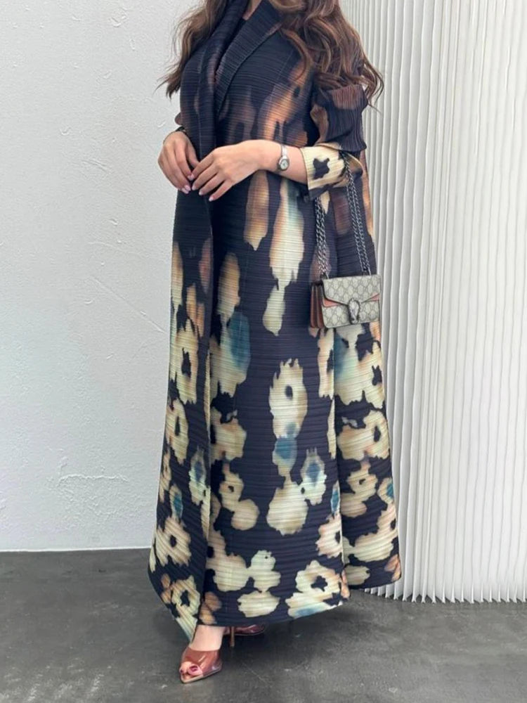 Person wearing a long, patterned coat with a white wall background