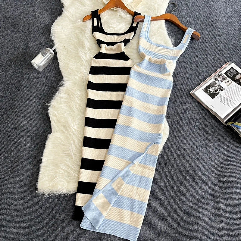 Two striped dresses on hangers against a textured surface with a magazine.