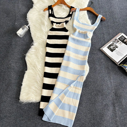 Two striped dresses on hangers against a textured surface with a magazine.