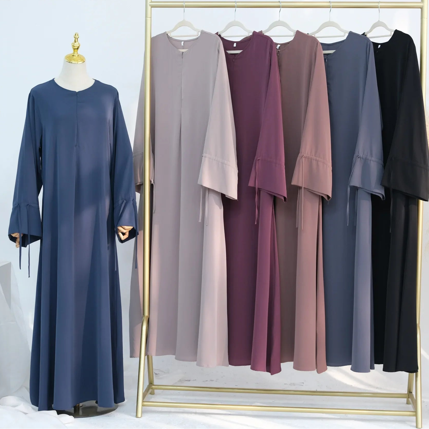 Collection of long dresses in various colors on a rack with CPENGA branding.