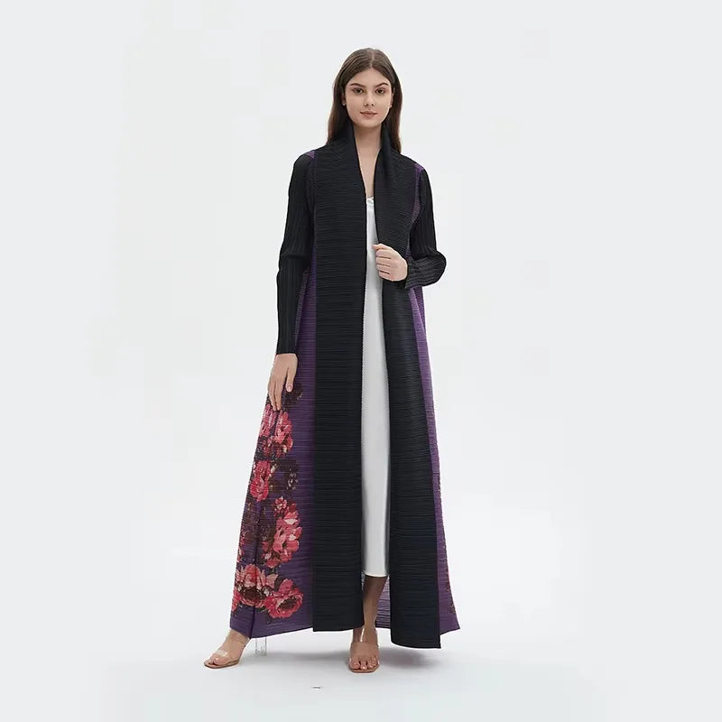 Woman wearing a long black coat with floral patterns on a white background