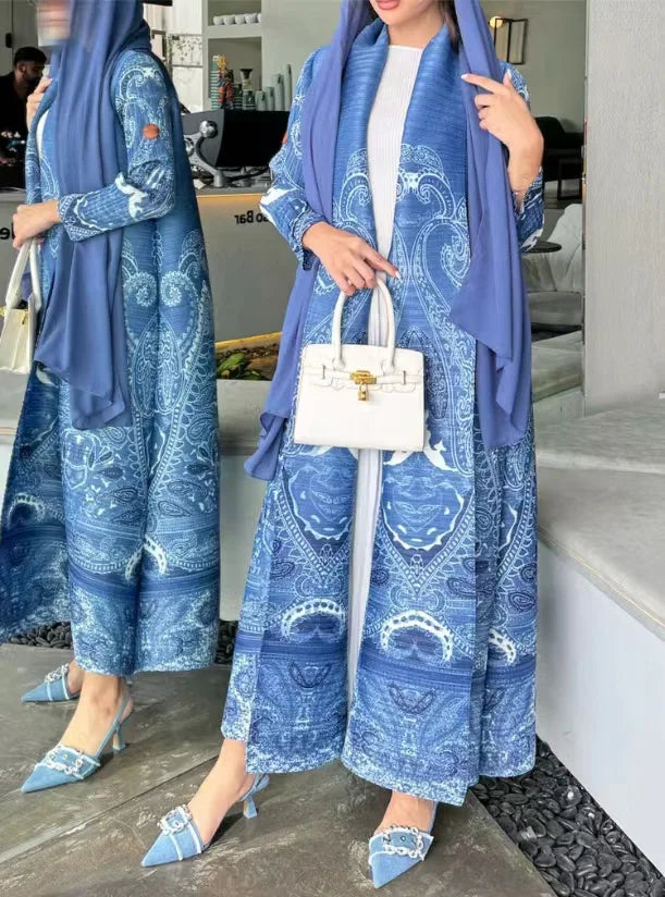 Two women in matching blue outfits with white patterns, standing indoors.