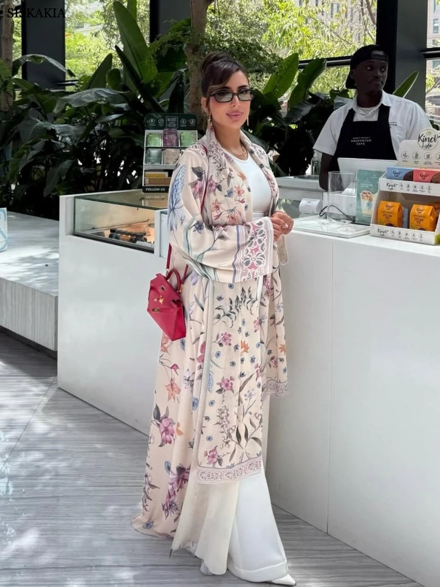 Woman in a floral kimono standing in front of a counter with plants in the background