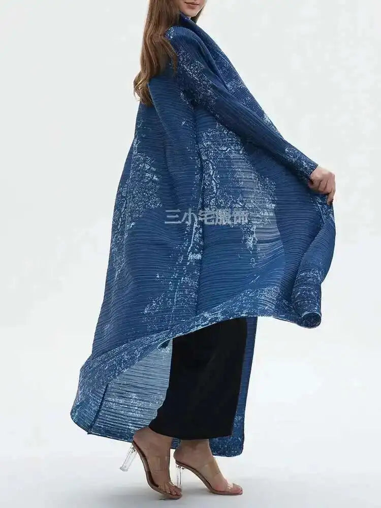 Woman wearing a long blue patterned dress against a white background